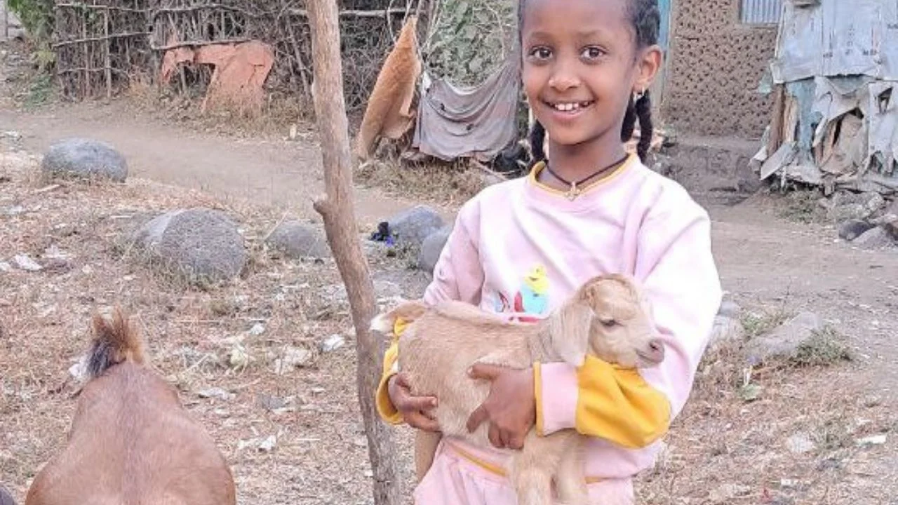 Marsilas tends to the goats raised with her family, a gift that helps them earn an income and build a more secure future.